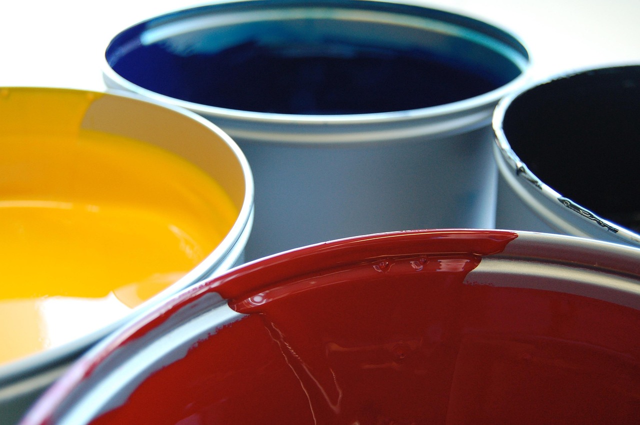 Botes de pintura de colores primarios en primer plano.