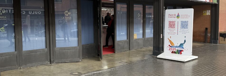 Entrada principal de la feria Paint & Coatings 2025 en Barcelona, con el cartel oficial del evento sobre las puertas de acceso.