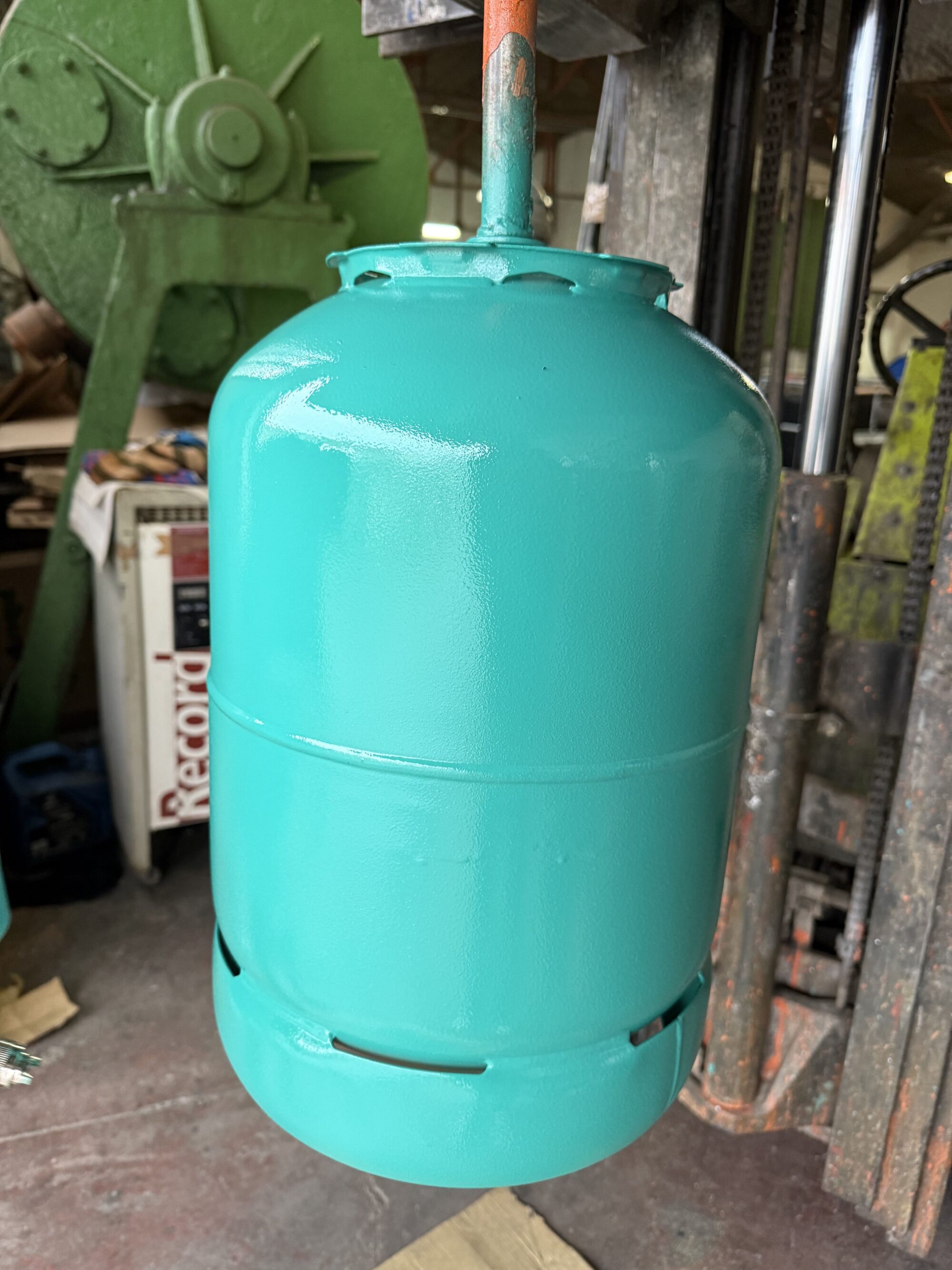 Botella de gas metálica pintada con esmalte industrial premium + de Dekoin 98 de color verde, mostrando un acabado brillante, uniforme y de alta calidad tras una aplicación real en entorno industrial.