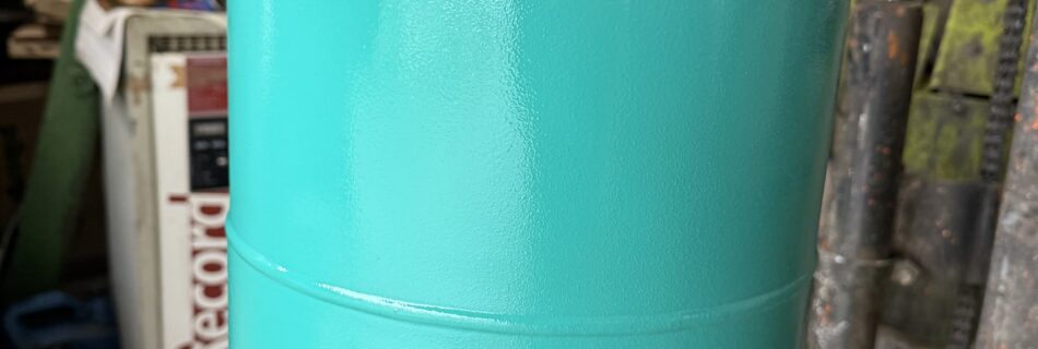 Botella de gas metálica pintada con esmalte industrial premium + de Dekoin 98 de color verde, mostrando un acabado brillante, uniforme y de alta calidad tras una aplicación real en entorno industrial.