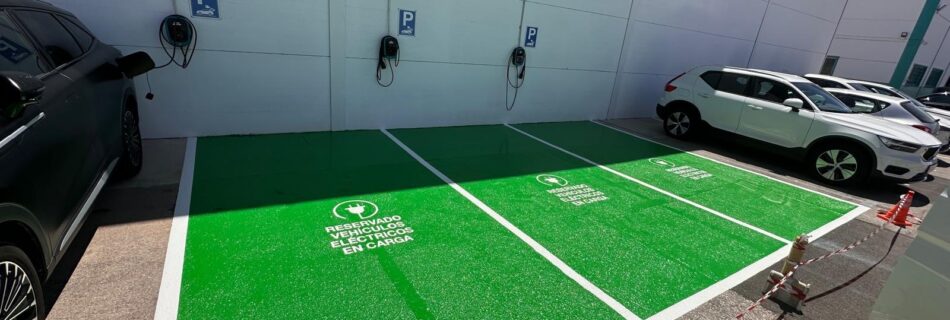 Zona de recarga para vehículos eléctricos señalizada con esmalte poliéster de Dekoin 98 de alta durabilidad aplicado sobre pavimento industrial.